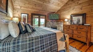 een slaapkamer met een bed in een blokhut bij Knotty By Nature in Blue Ridge