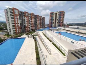 a large swimming pool next to some apartment buildings at Apartamento Casa Garzon in Girardot +6 photos