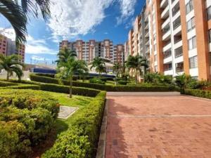 a brick walkway in a park with palm trees and buildings at Apartamento Casa Garzon in Girardot