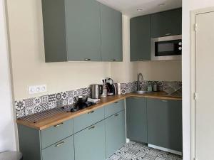 a kitchen with blue cabinets and a counter top at Studio Charme Ardennais in Charleville-Mézières +2 photos
