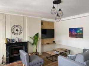 a living room with two chairs and a fireplace at Studio Charme Ardennais in Charleville-Mézières