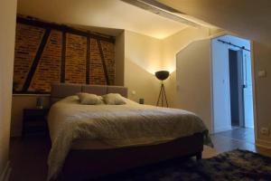 a bedroom with a bed and a lamp in it at Studio Charme Ardennais in Charleville-Mézières