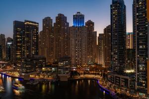 a city skyline at night with a river and tall buildings at Delta Hotels by Marriott Jumeirah Beach, Dubai in Dubai