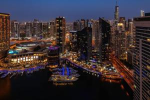 a city skyline at night with boats in the water at Delta Hotels by Marriott Jumeirah Beach, Dubai in Dubai