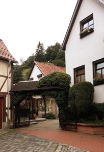 a white house with a gate and ivy on it at Ferienwohnung Alte Mühle in Stolberg i. Harz
