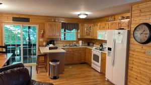 a kitchen with wooden cabinets and a white refrigerator at The Lake House At Dale Hollow! in Alpine