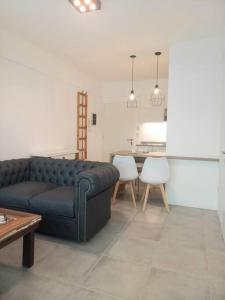 un salon avec un canapé bleu et une table dans l'établissement Excelente depto muy luminoso, à Buenos Aires