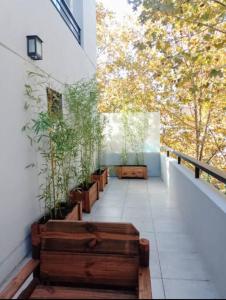 un balcon avec une rangée de bancs et d'arbres dans l'établissement Excelente depto muy luminoso, à Buenos Aires
