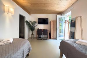 a bedroom with two beds and a tv on the wall at Ruhige Apartments mit guter Bahnanbindung und Küchennutzung in Rösrath