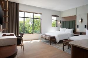 um quarto de hotel com duas camas e uma escrivaninha em Ada Hotel em Ada