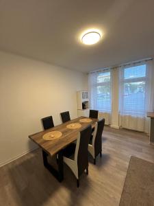 a dining room with a wooden table and chairs at Gera Apartment EG in Gera +9 photos