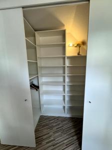 a closet with white shelves and a lamp at Stadtzauber in Malchow +1 photo