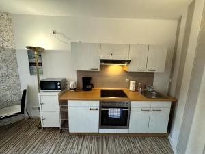 a small kitchen with white cabinets and a sink at Stadtzauber in Malchow