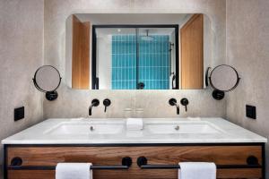 a bathroom with a tub and a large mirror at Four Points by Sheraton Matosinhos in Matosinhos
