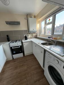 a kitchen with a sink and a stove top oven at Amirs house reed ave in Kent