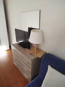 a bedroom with a tv and a lamp on a dresser at Casa Lilly in Omegna