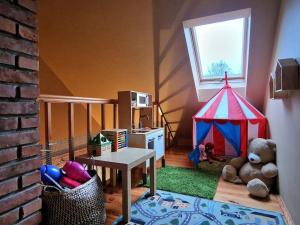 Una habitación con una tienda de juegos y un osito de peluche. en Agroturystyka Nad Bystra - Drewniany dom z pięknym ogrodem, en Bartłomiejowice