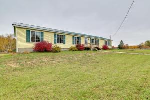 a yellow house with a lawn in front of it at Spacious De Tour Village Home Near Lake Huron! in De Tour Village