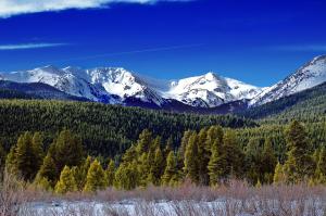 a snowy mountain range with trees and snow covered mountains at Baymont by Wyndham Fort Collins in Fort Collins