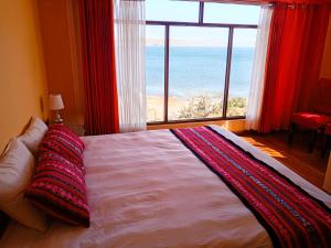 a bedroom with a large bed with a view of the ocean at "Casa de Valentin" in Llachon