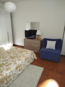 a bedroom with a bed and a blue chair at Casa Lilly in Omegna