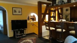 a living room with a flat screen tv and chairs at Ferienwohnung Alte Mühle in Stolberg i. Harz
