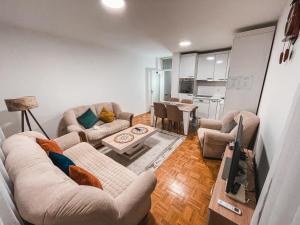 a living room with two couches and a table at Cozy Apartment in Gjilan in Gnjilane