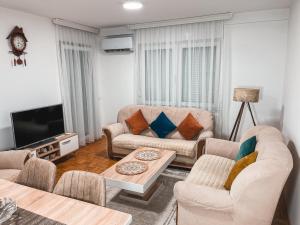 a living room with a couch and a table at Cozy Apartment in Gjilan in Gnjilane