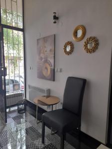 a chair in a room with a table and mirrors at Dream INN Sarajevo in Sarajevo