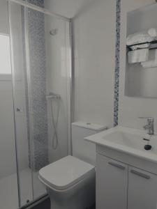a white bathroom with a toilet and a shower at Apartamento El Rincón del Nela in Villarcayo