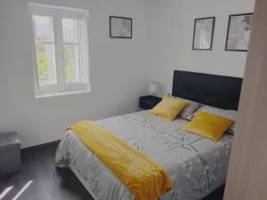 a bedroom with a bed with yellow pillows and a window at Apartamento El Rincón del Nela in Villarcayo