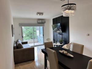 a dining room and living room with a table and chairs at Departamento con vista a la piscina in Pinamar