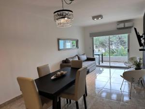 a dining room with a table and a couch at Departamento con vista a la piscina in Pinamar