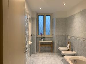 een badkamer met 2 toiletten, een wastafel en een raam bij Spazio Perlasca Apt 1 - Cernobbio Como Lake in Cernobbio +18 foto's