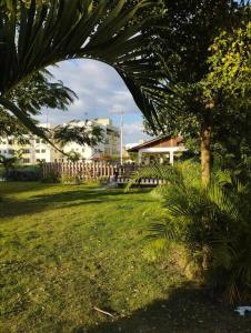 a green yard with a palm tree and buildings at Apartamento en Ciudad Juan Bosch in La Javilla