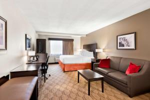 a hotel room with a bed and a couch at Best Western Palmyra Inn & Suites in Palmyra
