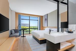 a hotel room with a bed and a sink and a tv at Fairfield by Marriott Beijing Daxing Airport in Beijing