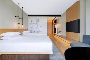 a hotel room with two beds and a couch at Fairfield by Marriott Beijing Daxing Airport in Beijing
