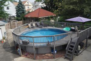 a swimming pool with a deck and an umbrella at Elizabeth New Jersey bedroom -Newark Airport -New York City in Elizabeth