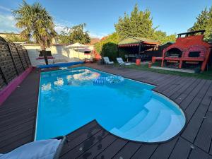 einen großen blauen Pool auf einer Holzterrasse in der Unterkunft Appartement de 65m2 avec piscine partagée in Tremblay En France