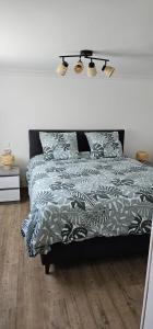 ein Schlafzimmer mit einem Bett mit einer grünen Bettdecke in der Unterkunft Appartement de 65m2 avec piscine partagée in Tremblay En France