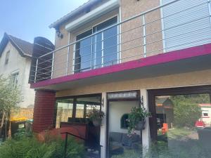 ein Haus mit großen Glastüren und einem Balkon in der Unterkunft Appartement de 65m2 avec piscine partagée in Tremblay En France