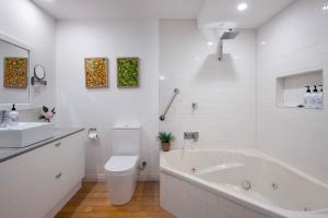een witte badkamer met een bad en een wastafel bij Aggies Way - dog friendly with panoramic views in Daylesford