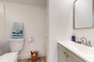 Un baño blanco con inodoro y lavabo. en Sunset Sanctuary, en Boothbay Harbor