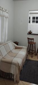 una camera da letto con un letto, una sedia e una finestra di Sea Like 2 - Casa para temporada ad Arraial do Cabo