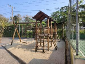 a playground with two chairs and a net at Apartamentos Gratitude in Ubatuba