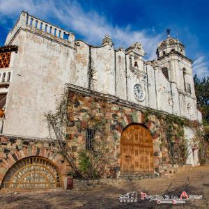 an old building with a clock on the side of it at Posada de la Mision, Hotel Museo y Jardin in Taxco de Alarcón
