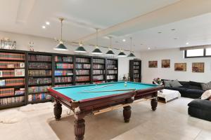 a living room with a pool table and books at Sunset Villa in Saronida