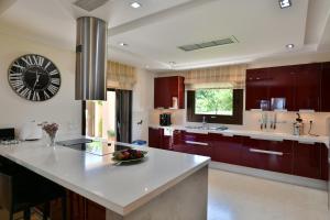 a large kitchen with a large counter and a clock at Sunset Villa in Saronida