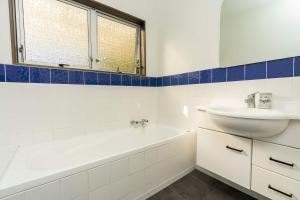 a white bathroom with a sink and a tub and a sink at Onerahi Oasis Outdoor entertainers delight in Whangarei +17 photos